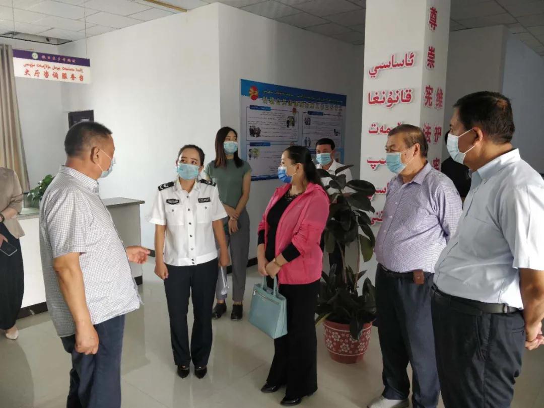 图为第一检查验收组在伽师县铁日木乡幸福村检查普法工作.